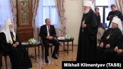 Довоєнна фотографія. Київ, Києво-Печерська лавра, 27 липня 2013 року. Зліва направо: Московський патріарх Кирило (Гундяєв), президент Росії Володимир Путін, митрополит Одеський та Ізмаїльський УПЦ (МП) Агафангел (Саввін) та митрополит Сімферопольський і Кримський УПЦ (МП) Лазар (Швець)