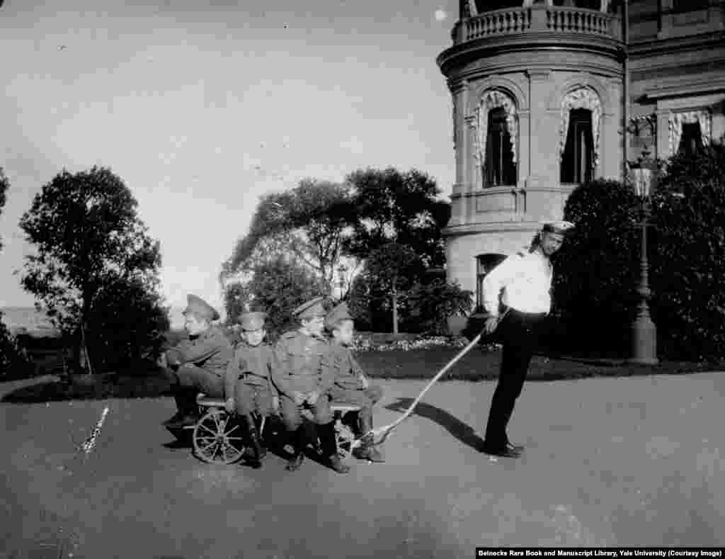 Klementy Nagorny (right) was also tasked with looking after Tsarevich Aleksei (second from right on trolley). After the 1917 revolution, Nagorny joined the royal family in captivity despite knowing it was likely he would be killed. While imprisoned with the Romanovs, he intervened to stop a Bolshevik guard from stealing Aleksei's gold chain; he was shot a few days later.