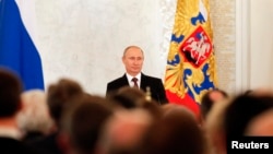Russian President Vladimir Putin on March 18, 2014, addresses the Federal Assembly, including State Duma deputies, members of the Federation Council, regional governors, and civil society representatives on the annexation of Ukraine's Crimea region.