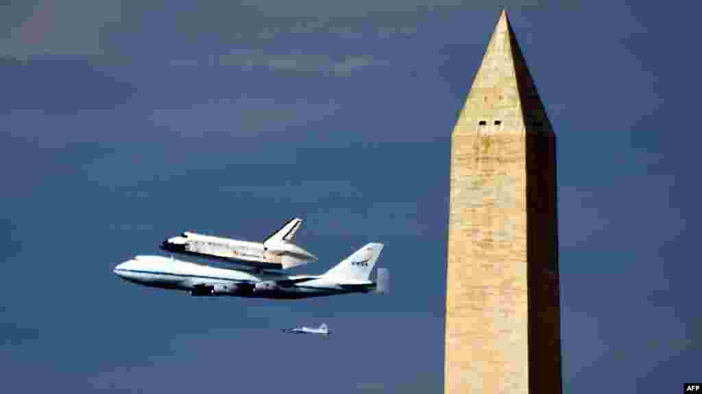 Американский космический челнок "Дикавери" на грузовом самолете НАСА над монументом Джорджа Вашингтона в столице США 17 апреля. "Дискавери" привезли из Космического центра имени Кеннеди во Флориде для показа в Музее национальной авиации и космонавтики в Вашингтоне. (AFP/Младен Антонов) 