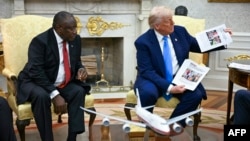 Президент США Дональд Трамп демонстрирует фотографии якобы убитых белых африканеров на встрече с президентом ЮАР Сирилом Рамафосой в Овальном кабинете Белого дома. Вашингтон, 21 мая 2025 года