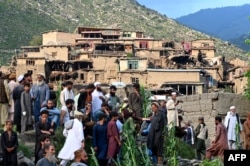 Săteni lângă casele avariate după cutremur, în estul Afganistanului.