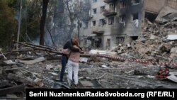 На месте российского ракетного удара по Киеву. По сообщениям, у этих людей в этом подъезде жил сын. 17 июня 2025 года