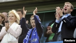 Chelsea owner Roman Abramovich (right) celebrates the team winning the English Premier League soccer trophy with his wife, Irina (left), and their son at Stamford Bridge in London in May 2007.