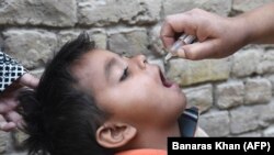 په بلوچستان کې یو روغتیايي کارکوونکی یو ماشوم ته د پولیو واکسیني څاڅکي ورکوي ـ پخوانی انځور.