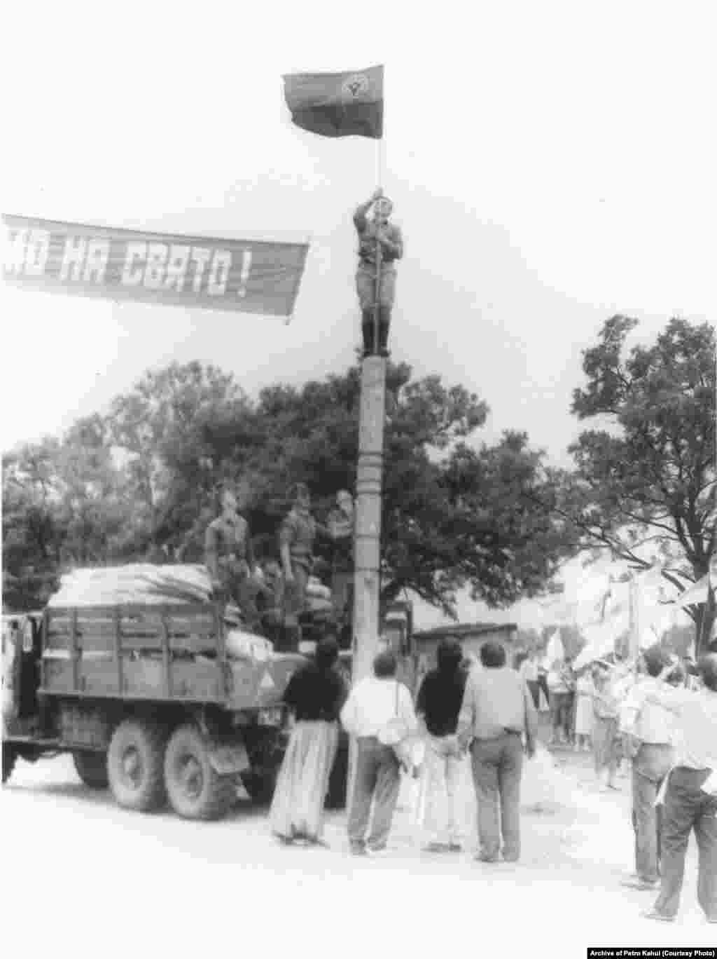 На фото &ndash; військові допомагають встановити червоно-чорний прапор із емблемою ОУН (р) на дерев'яному стовпі неподалік могили кошового отамана Запорізької Січі Івана Сірка