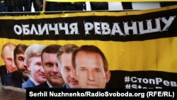 Плакат із зображенням українських олігархів і президента Росії Володимира Путіна під час акції «Стоп Реванш» біля Верховної Ради України. На акції вимагали ухвалення низки законів, спрямованих на боротьбу з російською агресією. Київ, 16 січня 2018 року