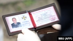 This handout picture taken and released on April 14 by the Security Service of Ukraine shows an officer reading a document of Valeriy Shaytanov during his arrest.