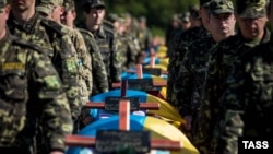 Ukrainian soldiers attend a mass funeral ceremony near Zaporizhzhya on October 1 to bury unidentified members of pro-Ukrainian military forces who were killed in fighting in the country's east.