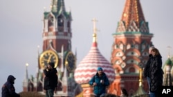 Disa persona duke ecur në parkun Zariadie në Moskë, teksa në prapavijë shihet ndërtesa e Kremlinit. Fotografi ilustruese nga arkivi. 