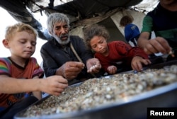 Palestinieni strămutați care nu au primit ajutor umanitar adună resturi de mâncare, Gaza, 28 iulie 2025.