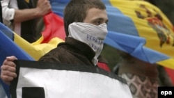 A Moldovan protester holds a sign reading 'Europe Help Us.' Events in Chisinau have shown unexpected instability just beyond the EU's borders.
