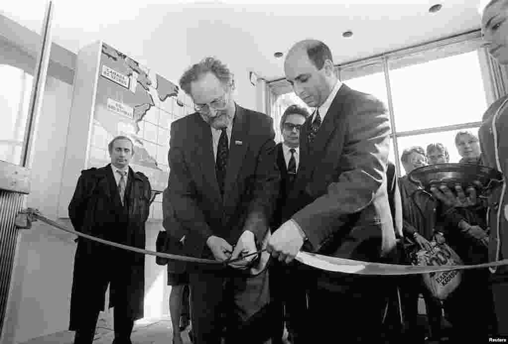 Putin (left), chairman of St. Petersburg's External Relations Committee, takes part in a ceremony to open an electronics store in St. Petersburg on April 29, 1993.