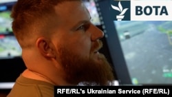 Një ushtar ukrainas vëzhgon ekranet duke transmetuar imazhe nga kamerat e dronit të pozicioneve ruse që mund të shënjestrohen nga artileria.