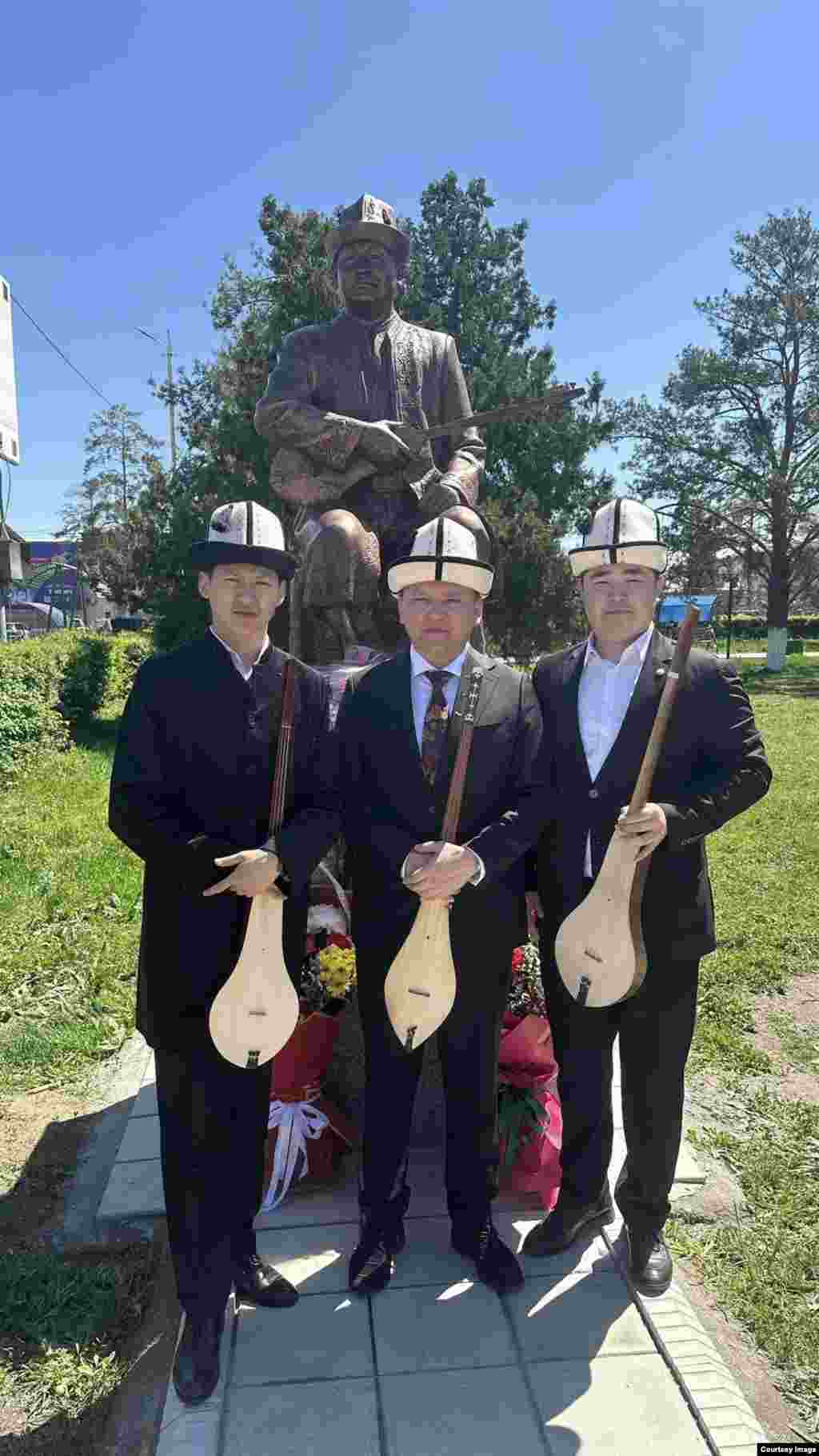 Элмирбек Иманалиевдин шакирттери анын эстелигинин алдында. 