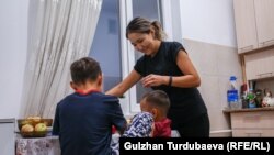 Айнура кормит детей ужином.