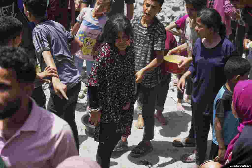 Palestinci čekaju da napune svoje posude sa hranom u Džabaliji, 19. maja.