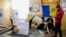 Ребенок голосует за родственника во время президентских выборов и референдума о вступлении в ЕС на избирательном участке для жителей Приднестровского региона в Варнице 