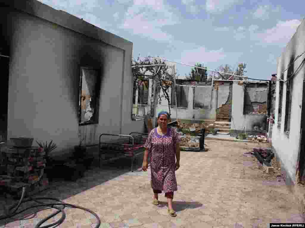 Өрттөн кыйраган үйүнүн короосунда турган аял. Ош. 20-июль, 2010-жыл.