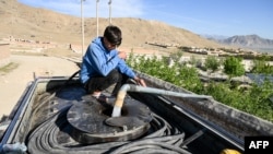 Жас бала Кабул шетіндегі құдықтан су құйып алып жатыр. 27 сәуір, 2025 жыл. (Photo by Wakil KOHSAR / AFP)