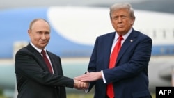 Președintele SUA, Donald Trump (dreapta), îl salută pe președintele rus Vladimir Putin pe pista aeroportului Joint Base Elmendorf-Richardson din Anchorage, Alaska, pe 15 august.
