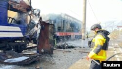 მეხანძრე შოსტკაში სამგზავრო მატარებელთან რუსეთის არმიის დრონით იერიშის შემდეგ. უკრაინის პოლიციის მიერ მოწოდებული ფოტო.
