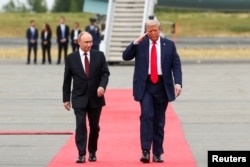 Cei doi lideri, pe covorul roșu, la baza militară Elmendorf-Richardson din Anchorage, Alaska.