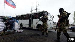 Куралчан орусиячыл активисттер Славянск шаарынын четиндеги бекетте автобусту текшерүүдө.  30-апрель, 2014.