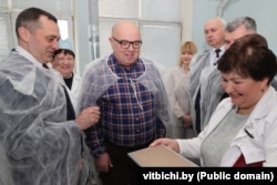 Kryetari i Komitetit Ekzekutiv Rajonal të Vitsebsk, Alyaksandr Subotsin (majtas), drejtori i fabrikës Alyaksandr Shumakher (në qendër) dhe Kryetari i Bordit të Drejtorëve të fabrikës Manalit, Akif Hasymau (djathtas) gjatë një vizite në fabrikën e prodhimit, në mars 2024.