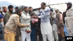 Members of Jamaat-ud-Dawa distributing food at a relief camp in Muzaffarabad