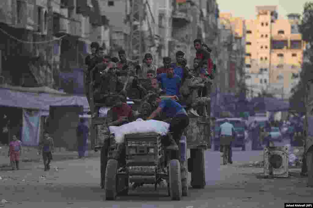 Palestinezë në rimorkion e një traktori me ndihma të siguruara nga veriu i Rripit të Gazës, duke lëvizur nëpër një rrugë në Qytetin e Gazës, më 29 gusht.