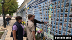 Андрей Коломиец с родителями около стены памяти в Киеве