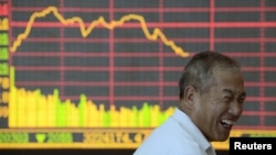 Инвестор баалуу кагаздардын наркын көрсөтчү электрондук монитордун алдына. Шанси провинциясындагы Тайюан шаарындагы фондулук биржа. 9-июль, 2012