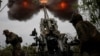 Un grup de soldați ucraineni manevrând un tun Howitzer în regiunea Harkov, Ucraina, 21 iulie 2022.