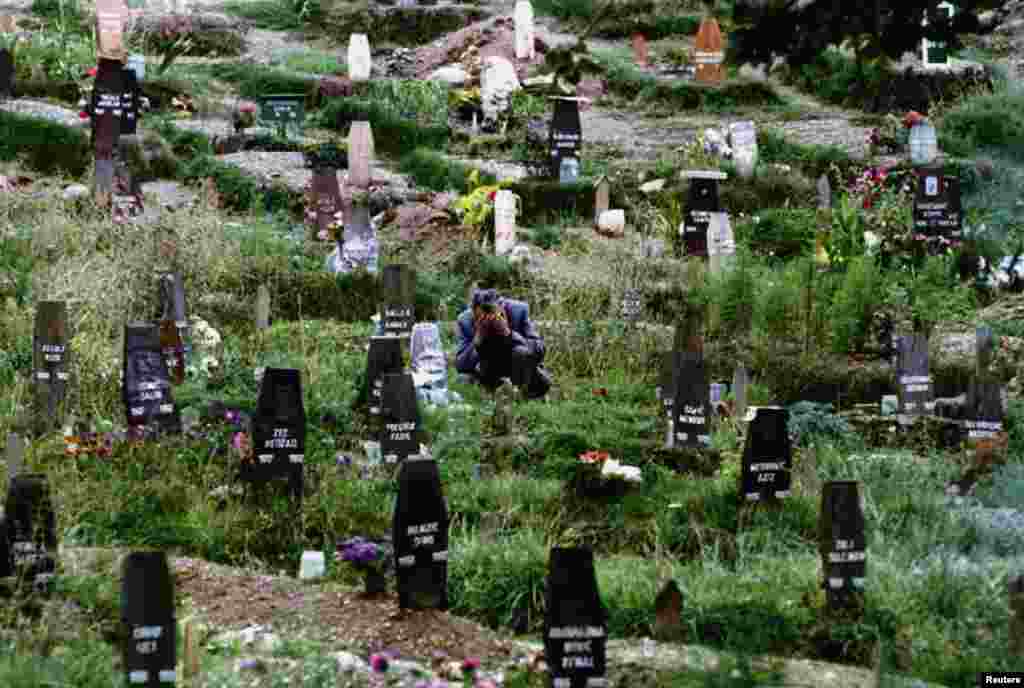 A man mourns his wife in one of Sarajevo's ever-expanding cemeteries in 1993.&nbsp;