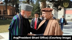 محمد اشرف غنی رئیس جمهور افغانستان حین دیدار با حامد کرزی رئیس جمهور پیشین این کشور.