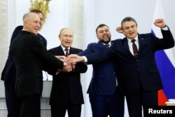 Ruski predsednik Vladimir Putin i lideri koje je postavila Rusija u ukrajinskim regionima Donjeck, Lugansk, Herson i Zaporožje slave na ceremoniji potpisivanja 30. septembra.