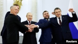 Președintele rus Vladimir Putin scandează „Rusia! Rusia!”, alături de Denis Pușilin, Leonid Pasechnik, Vladimir Saldo, Evgheni Balîțki, liderii instalați de Rusia în regiunile ucrainene Donețk, Luhansk, Herson și Zaporojie, în Sala Georgievski a Palatului Marelui Kremlin din Moscova, 30 septembrie 2022.