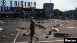 Un bărbat trece pe lângă un centru comercial lovit de o rachetă rusă în regiunea Dnipro din Ucraina, pe 26 iulie.