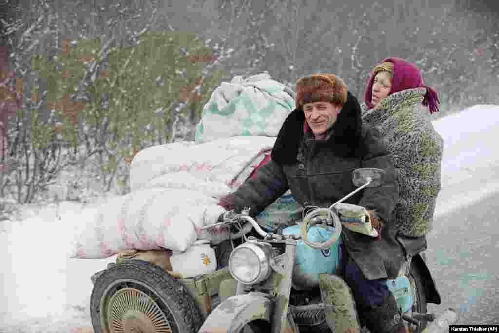 Čečenski par napušta Grozni sa stvarima koje su spakovali na motor, dok ruske snage napreduju ka glavnom gradu, 26. januar 1995. godine