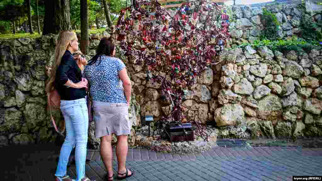 Дівчата розглядають &laquo;дерево закоханих&raquo;. Пам'ятник з'явився в січні 2015 року. Молодята вішають на нього замки, що символізують міцність відносин