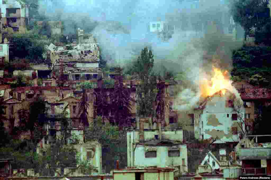 A house burning in Sarajevo after a direct hit from a mortar in 1994. A UN commission concluded in 1994, with the siege still continuing, that property damage "includes specifically protected targets such as hospitals and medical complexes, medical facilities...medical personnel, as well as cultural property" and tens of thousands of apartments.