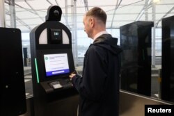 Un bărbat utilizează un chioșc automatizat EES în timpul unei demonstrații a Sistemului de Intrare/Ieșire al Uniunii Europene, la terminalul Eurotunnel din Folkestone, Marea Britanie, 23 septembrie 2025