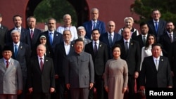 Președintele chinez Xi Jinping și soția sa Peng Liyuan, alături de președintele rus Vladimir Putin și liderul nord-corean Kim Jong Un la Beijing, în mijlocul altor înalți participanți, inclusiv foștii premieri români, Adrian Năstase și Viorica Dăncilă (în rândul de sus).
