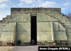 Два лётчыкі-аматары запавольваюць рух браняваных дзьвярэй, адкрыўшы ангар савецкай вытворчасьці на аэрадроме Мілавіцэ.