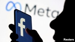 يو تن په خپل موبايل فون کې فېسبوک ګوري - انځور له ارشيفه