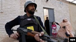 Pakistani security officials protect health workers as they administer Polio vaccination to children in Peshawar last month.