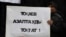 Қаңтар құрбандарын еске алу акциясында Қазақстан президенті Қасым-Жомарт Тоқаевтан азаптауды тоқтатуды талап еткен үндеу жазылған плакат ұстап тұрған адам. Алматы, 13 ақпан 2022 жыл.