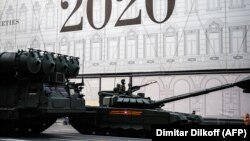 A Russian Army soldier rides a T-90 tank along a street prior to a rehearsal for a Victory Day parade in Moscow on June 17.