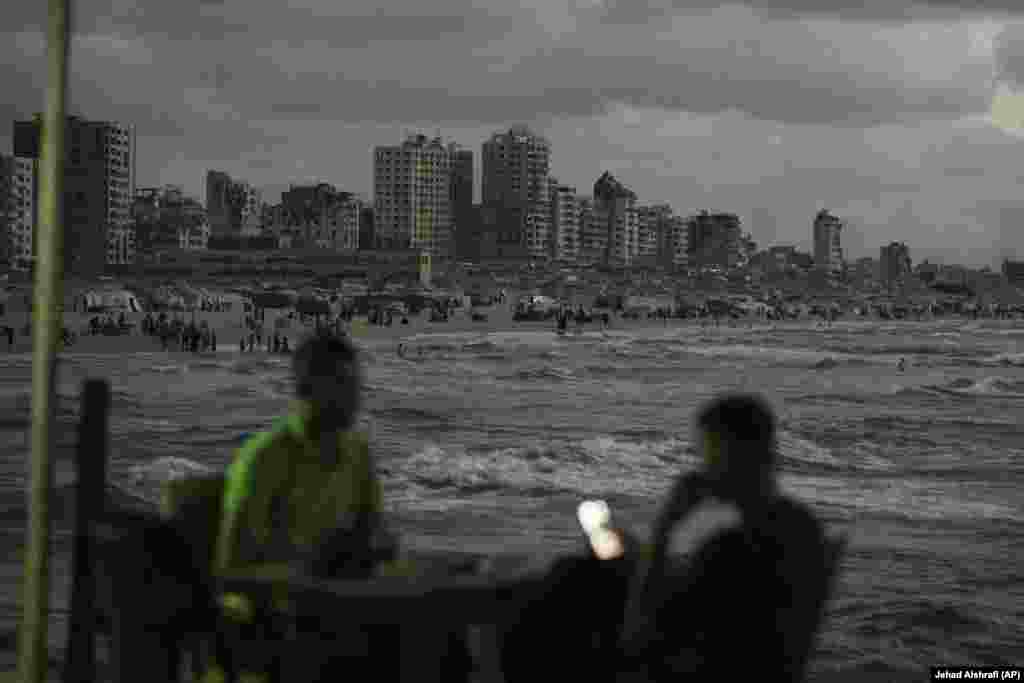 Palestinezë duke kaluar kohën buzë detit, pranë një kampi në Qytetin e Gazës.